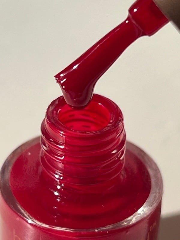 Deep red nail polish bottle photographed close up