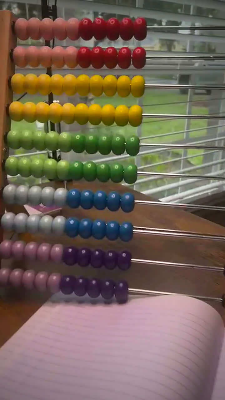 Colourful wooden abacus on a desk in bright window light