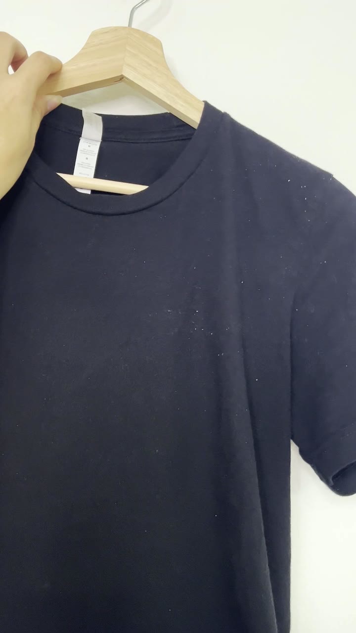 Black shirt on a hanger with dandruff flakes, opening of the Nizoral video