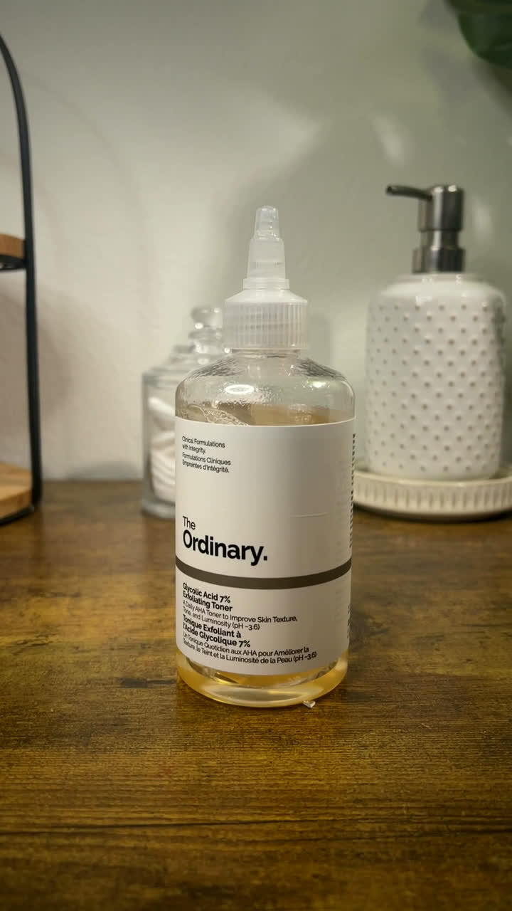 The Ordinary Glycolic Acid Toner bottle styled on a wooden bathroom shelf